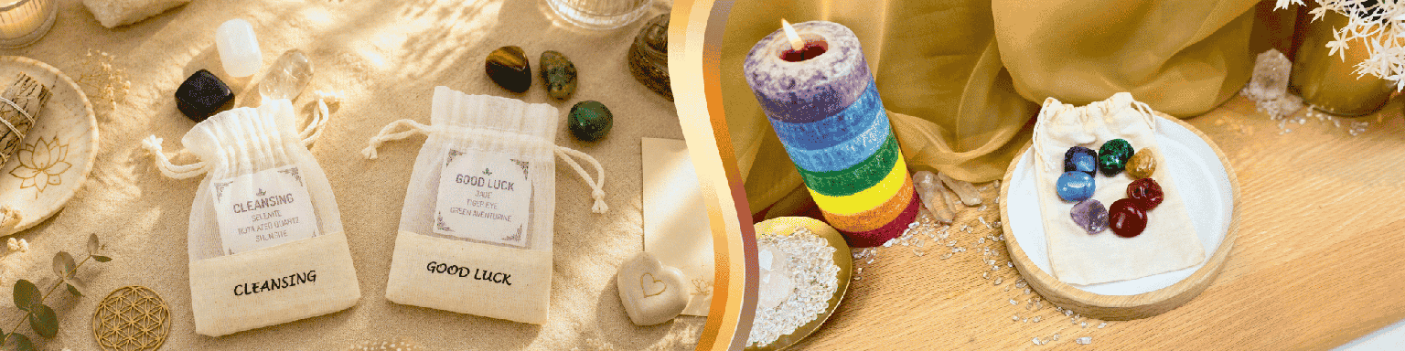 A display of spiritual and wellness items. On the left, two small white drawstring pouches labeled “Cleansing” and “Good Luck” are surrounded by crystals and decorative objects. On the right, colorful stacked candles and polished gemstones are arranged on a wooden surface beside a white dish, surrounded by crystals and other decorative items.